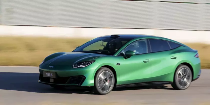 Зеленый электроседан BYD Formula S в движении на трассе