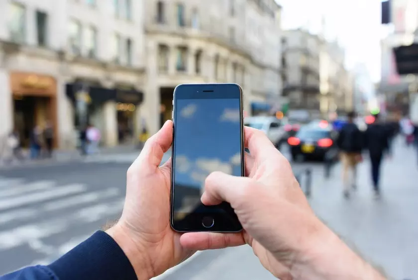iPhone в руках пользователя на улице