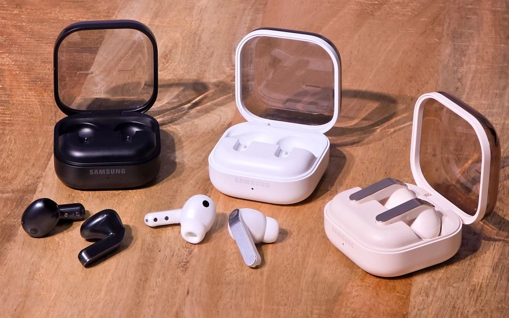 Trois écouteurs sans fil Samsung avec boîtiers de charge sur table