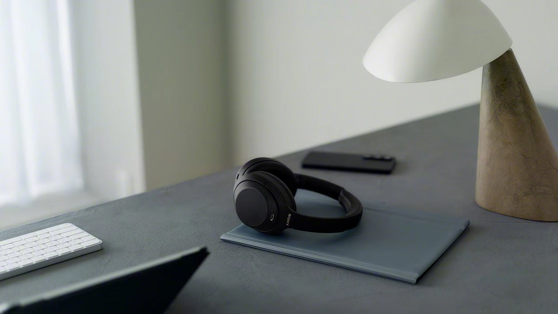 Casque noir posé sur un bureau avec lampe design