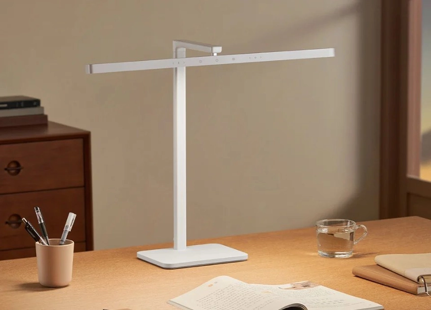 Lampe de bureau blanche vue de face sur un bureau en bois