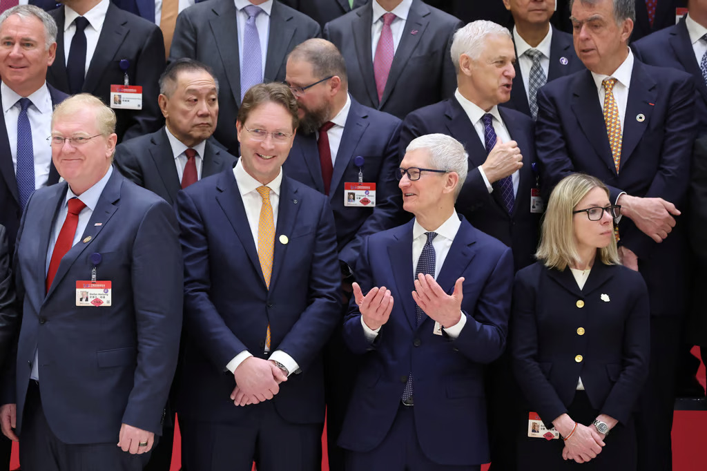 Tim Cook talks to other participants before the opening ceremony of the China Development Forum in Beijing